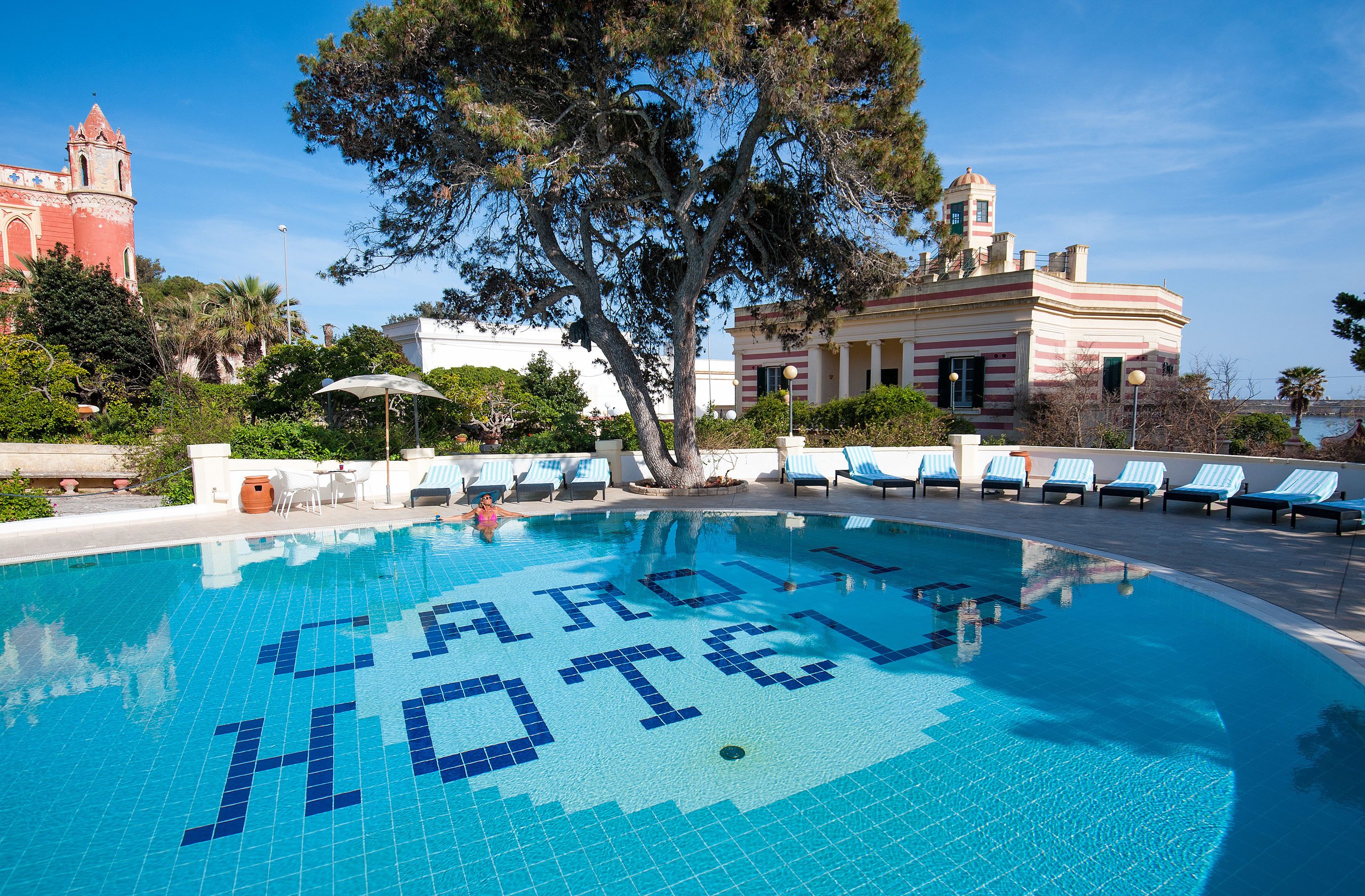 Una piscina con las palabras "CARDINAL HOTEL" escritas en mosaico en el centro.