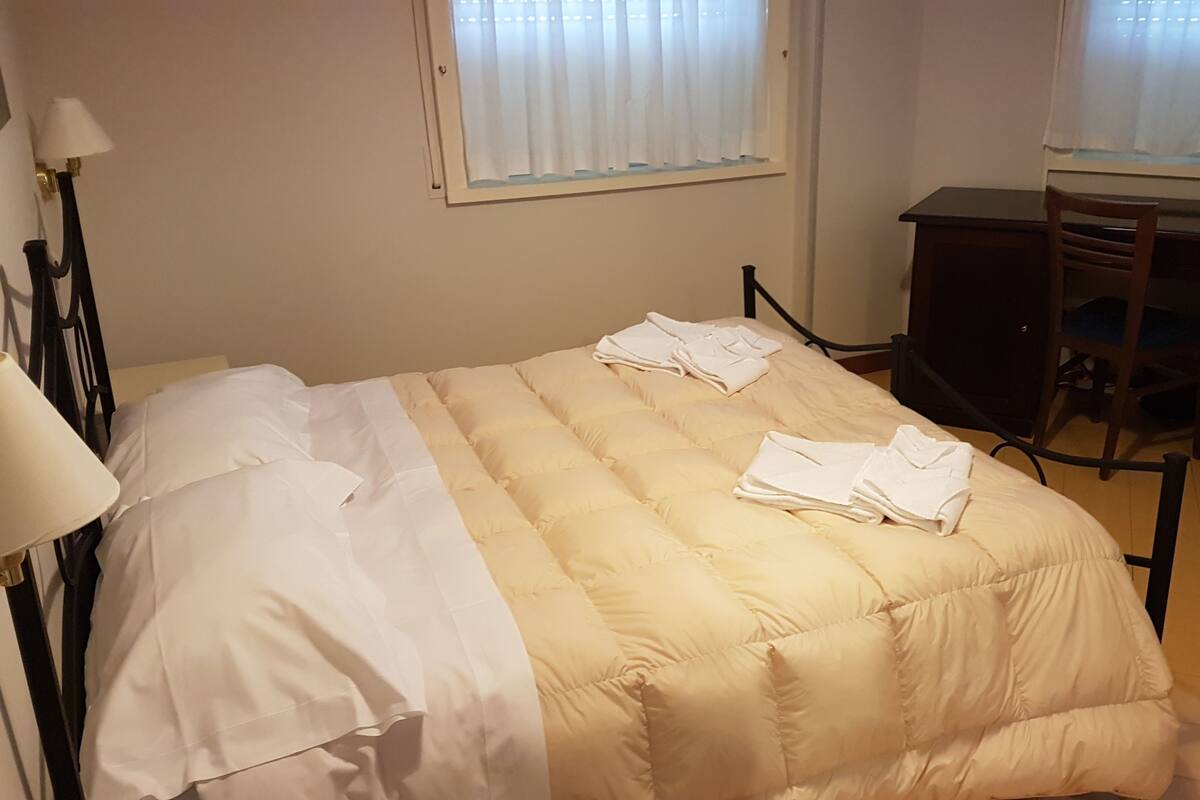 Una habitación de hotel con una cama, un escritorio y una silla.