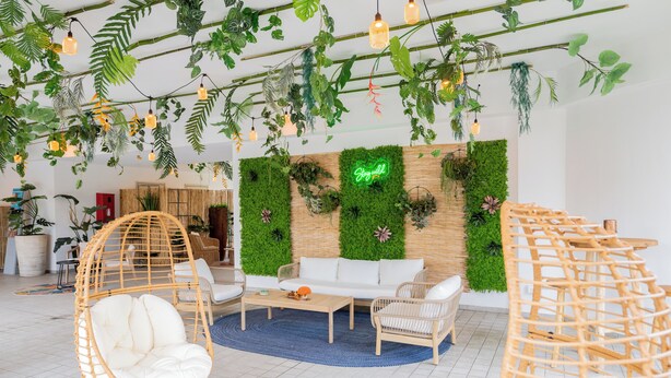A modern living room with a white sofa, wicker chairs, and a coffee table. - Bleis Hotel (Bologna)