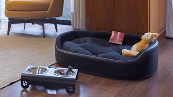 Uma cama para animais de estimação com um brinquedo e um comedouro.
