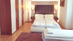 Ein Hotelzimmer mit zwei Betten, einem Holzschrank, einem Nachttisch mit Lampe und einem gemusterten Teppich.