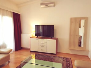 Deluxe appartement, 1 slaapkamer, balkon, uitzicht op de stad | Woonruimte | Een 30-inch televisie met kabelzenders