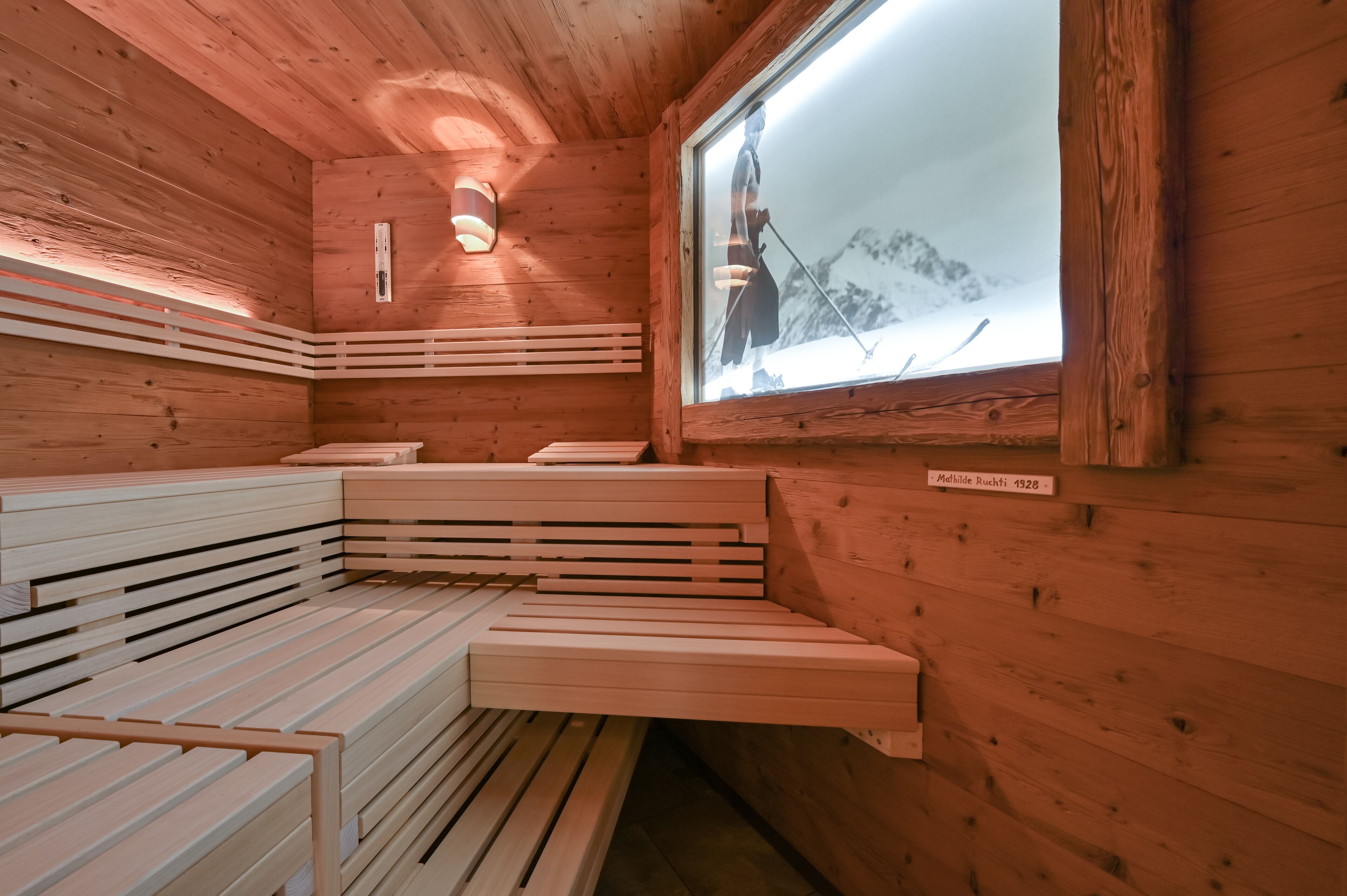 Una sauna de madera con bancos y una ventana.