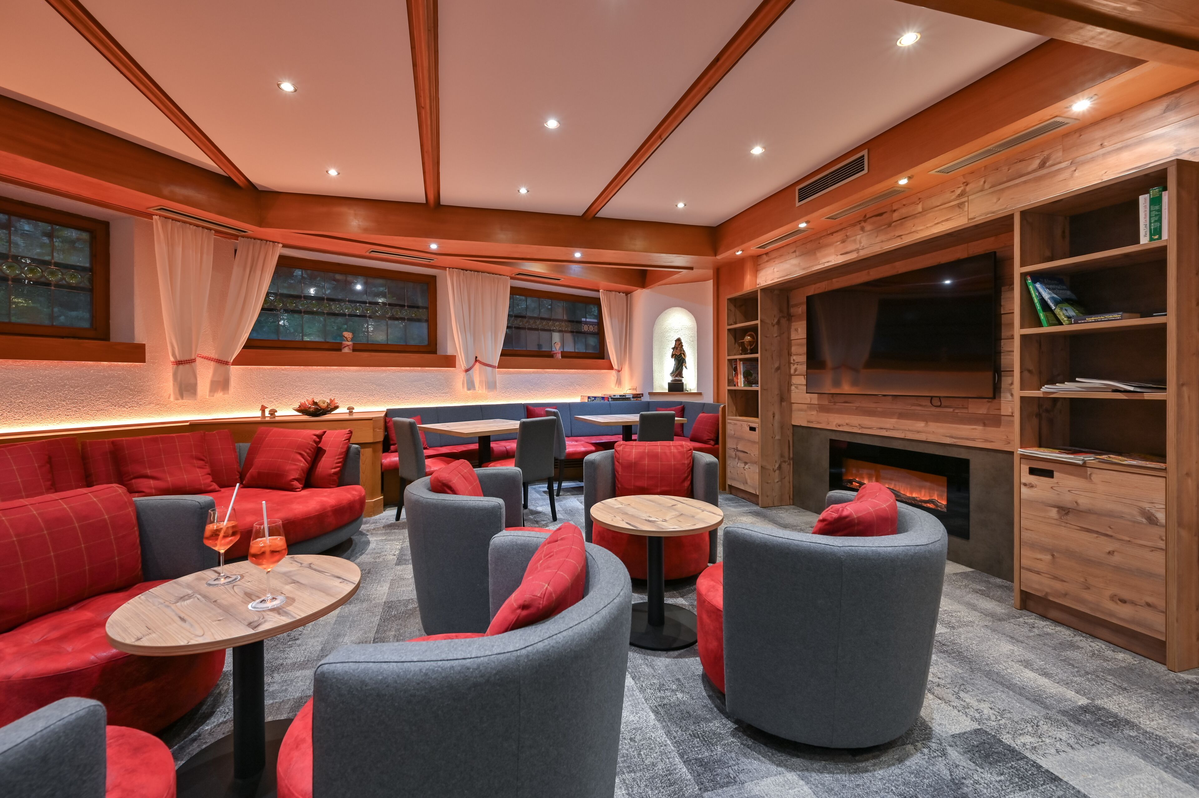 Cómoda sala de estar con sofás, sillones y mesas, una chimenea y un televisor.
