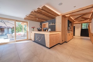 Een moderne receptie met een houten balie, een groot raam en een trap naar een andere verdieping.