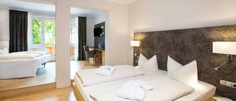 A hotel room with two beds, a desk, and a chair.