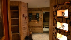 A wooden interior with a staircase, a bench, and shelves with heart-shaped decorations. - Hotel Bergruh (Fuessen)
