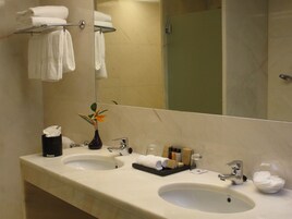Une salle de bain d’hôtel avec deux lavabos, un miroir et un porte-serviettes.
