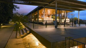 A modern building with a covered outdoor area, glass walls, and a staircase leading to an upper level. - Quinta Da Casa Branca (Funchal)