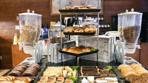 Ein Buffet mit verschiedenen Speisen, darunter Gebäck, Sandwiches und Desserts.
