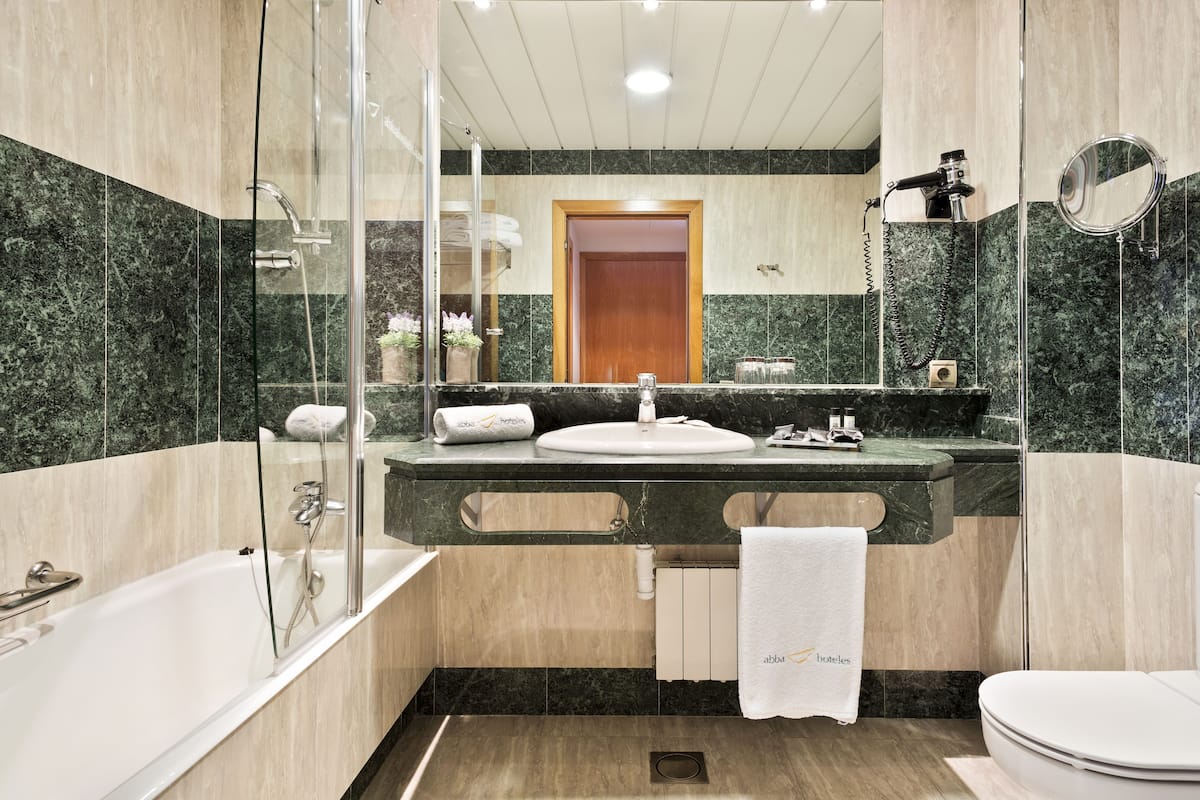 bathtub, designer toiletries, hair dryer, bidet