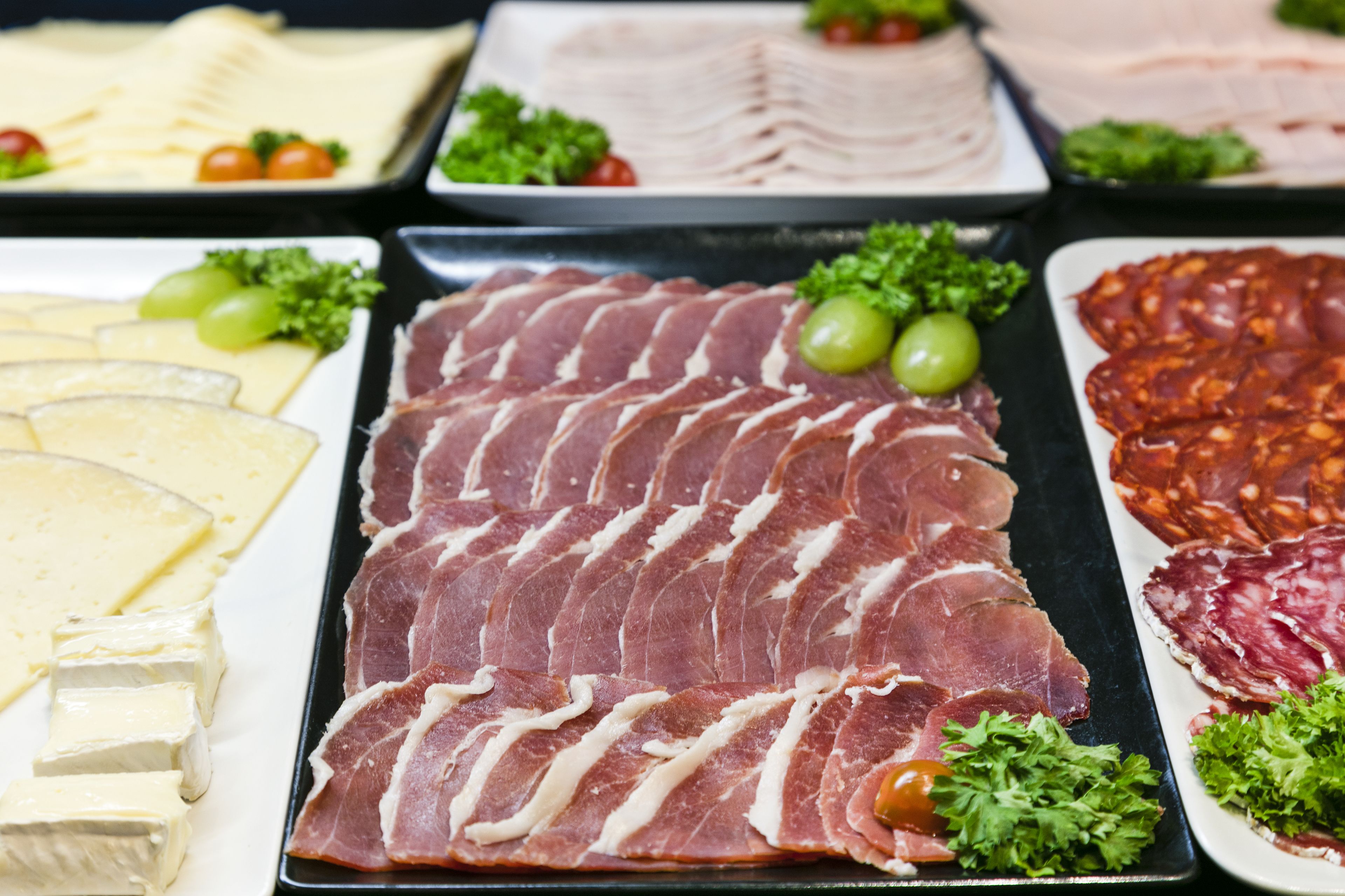 A variety of cheeses, cured meats, and charcuterie on a tray.