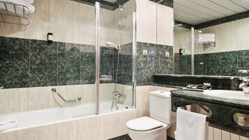 A modern bathroom with a glass-enclosed shower, a bathtub, a toilet, and a sink.