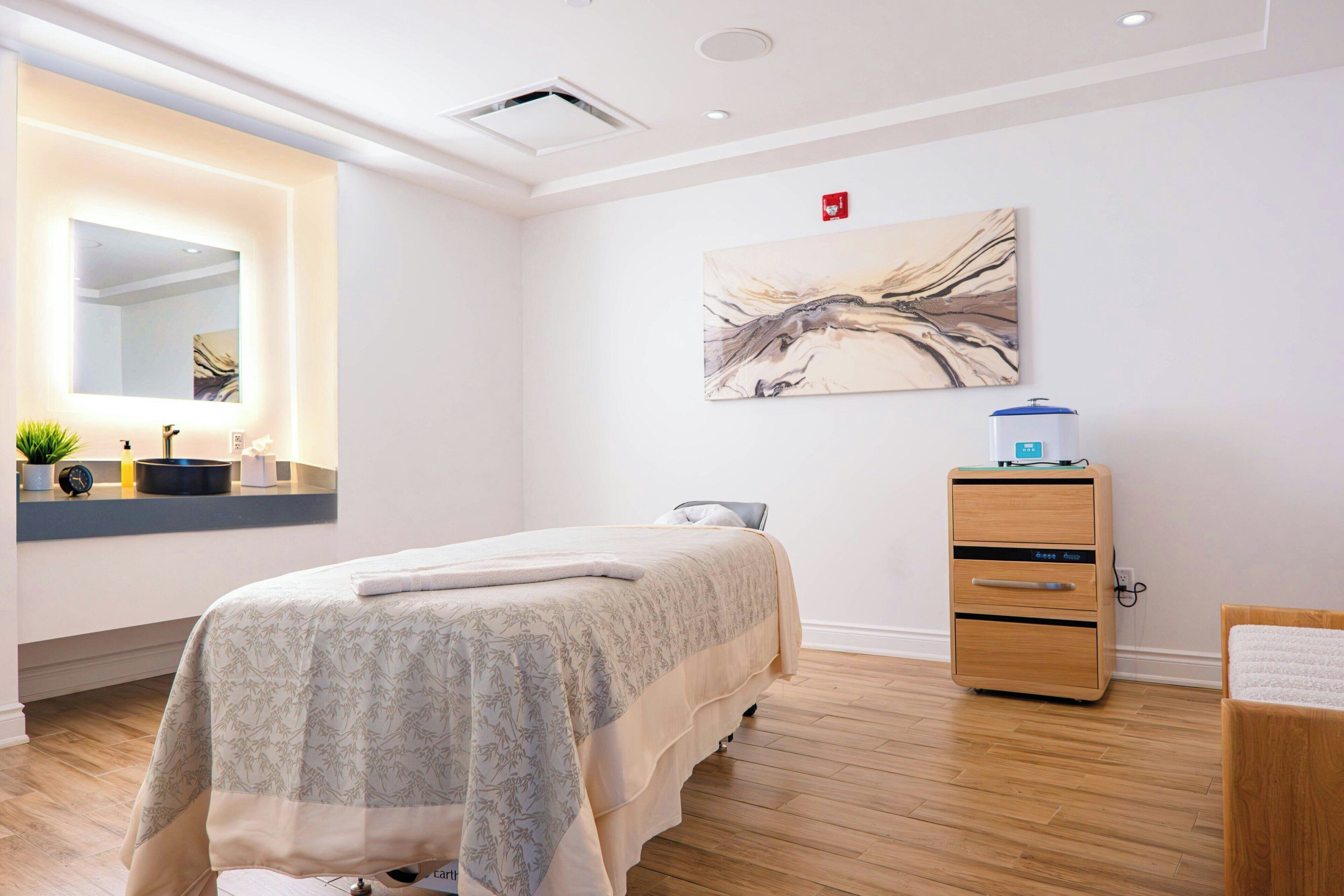 Un dormitorio moderno con cama, mesita de noche y calentador de pared.