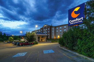 Un hotel Comfort Inn & Suites con un estacionamiento, una entrada techada y un letrero grande.
