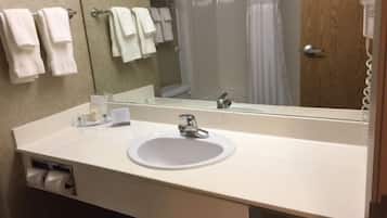 A bathroom with a sink, mirror, and towel rack.