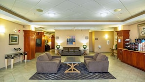 A lobby with a sofa set, a coffee station, and a reception desk.
