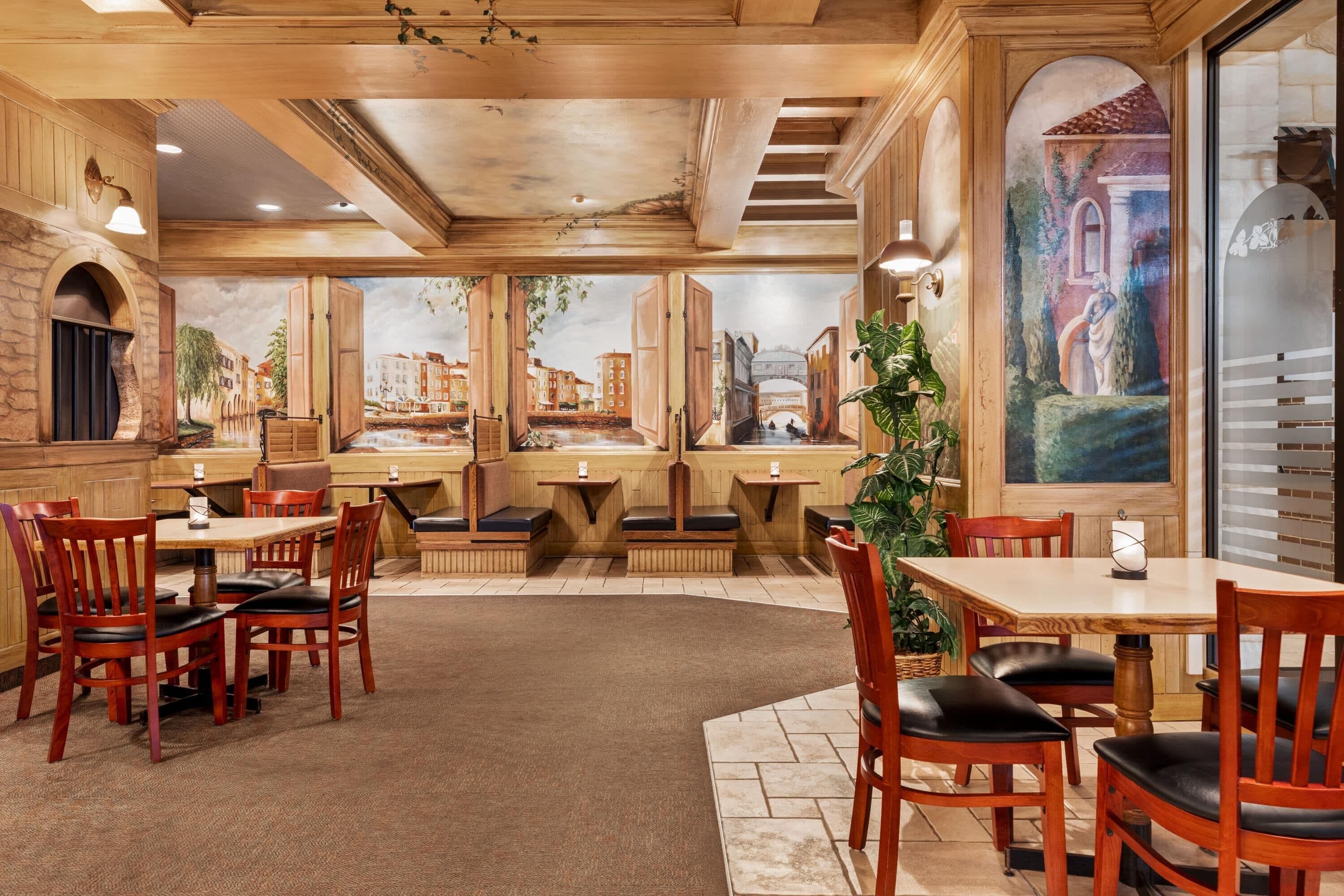 Un restaurante con interior de madera, varias zonas de estar y murales de un paisaje urbano.