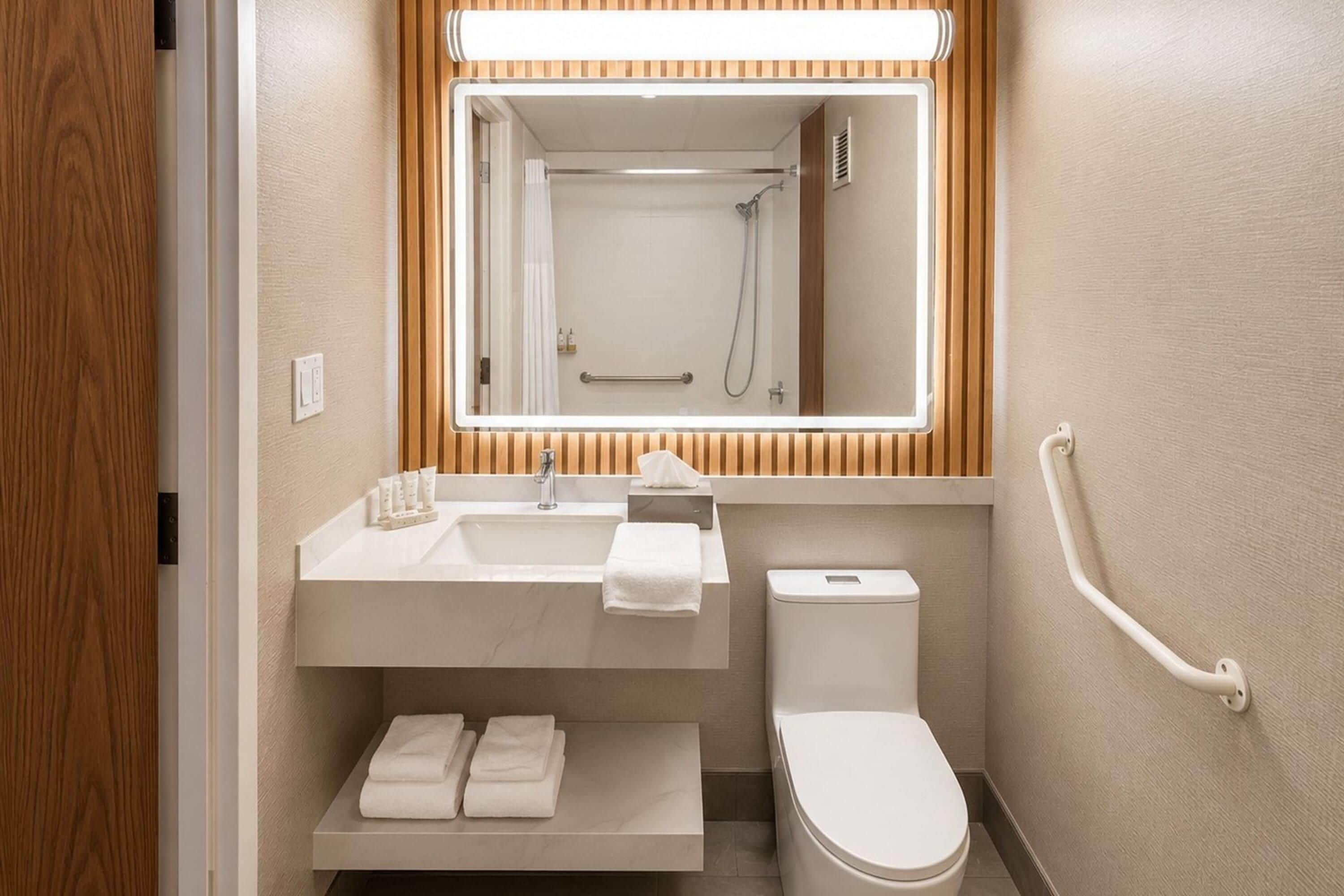 A modern bathroom with a sink, toilet, and shower.