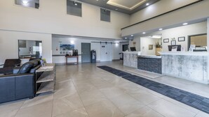 Un hall espacioso con mostrador de recepción, zona de estar y un amplio ventanal.