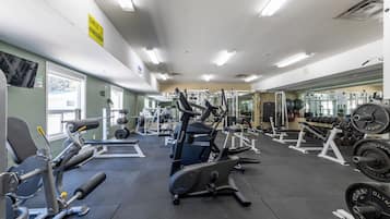 Une salle de sport équipée de divers appareils d’exercice, notamment des tapis de course et des appareils de musculation.
