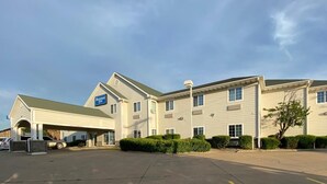A two-story hotel with a covered entrance and a parking lot.