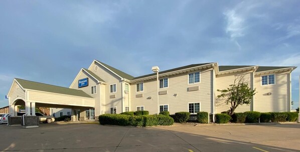 A two-story hotel with a covered entrance and a parking lot.