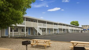 A motel with multiple rooms, a parking lot, and picnic tables. - Days Inn by Wyndham West Yarmouth/Hyannis Cape Cod Area (West Yarmouth)