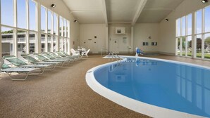 An indoor swimming pool with lounge chairs and a clear view of the outside. - Days Inn by Wyndham West Yarmouth/Hyannis Cape Cod Area (West Yarmouth)