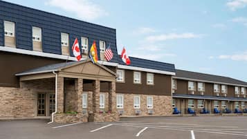Hotel features a flat roof, stone and brick exterior, and a covered entrance with a small porch.