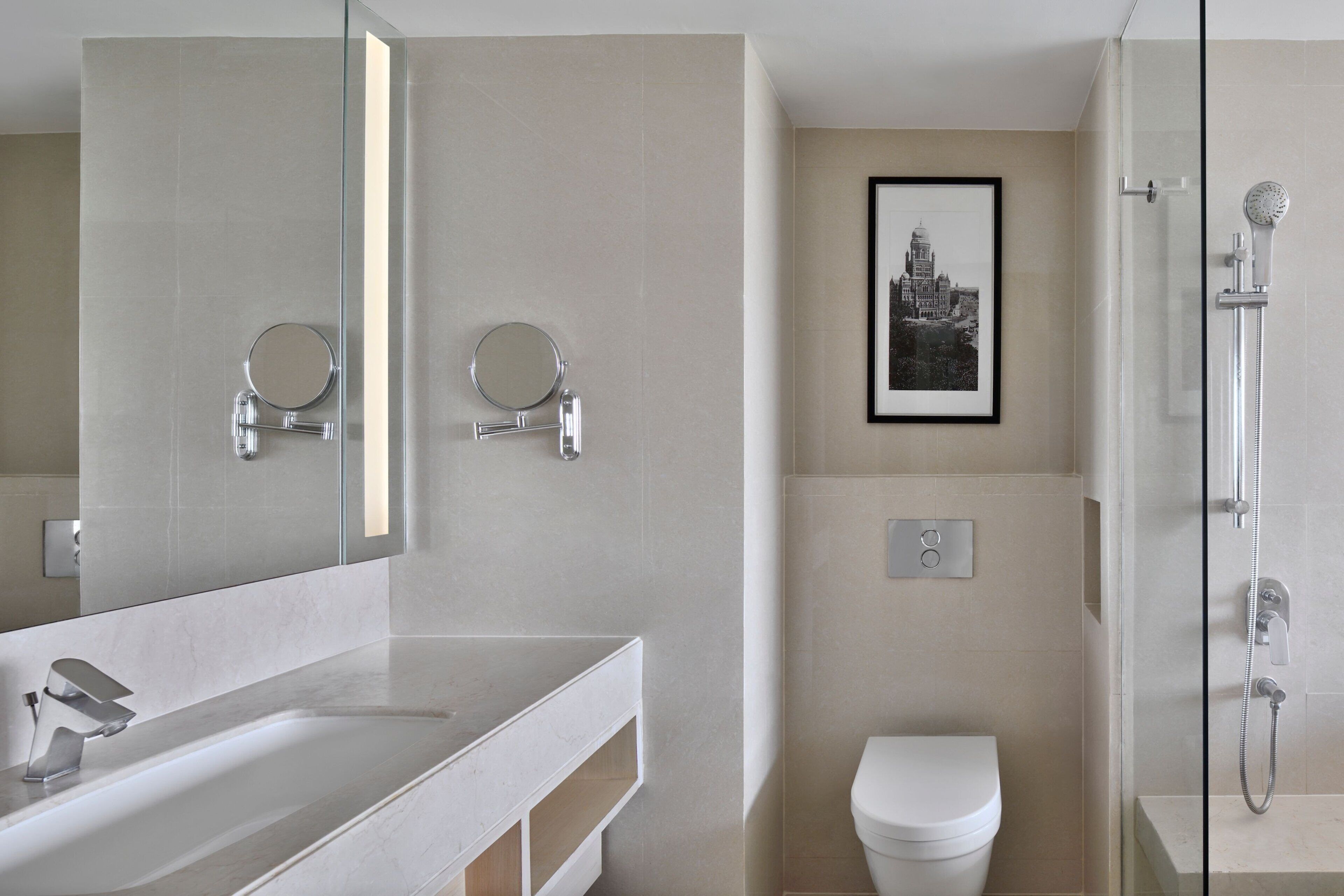A modern bathroom with a large mirror, a sink, a toilet, and a shower.