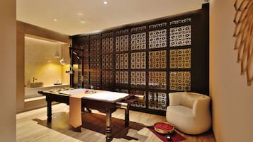 A room with a billiards table, a sofa, and a decorative partition.