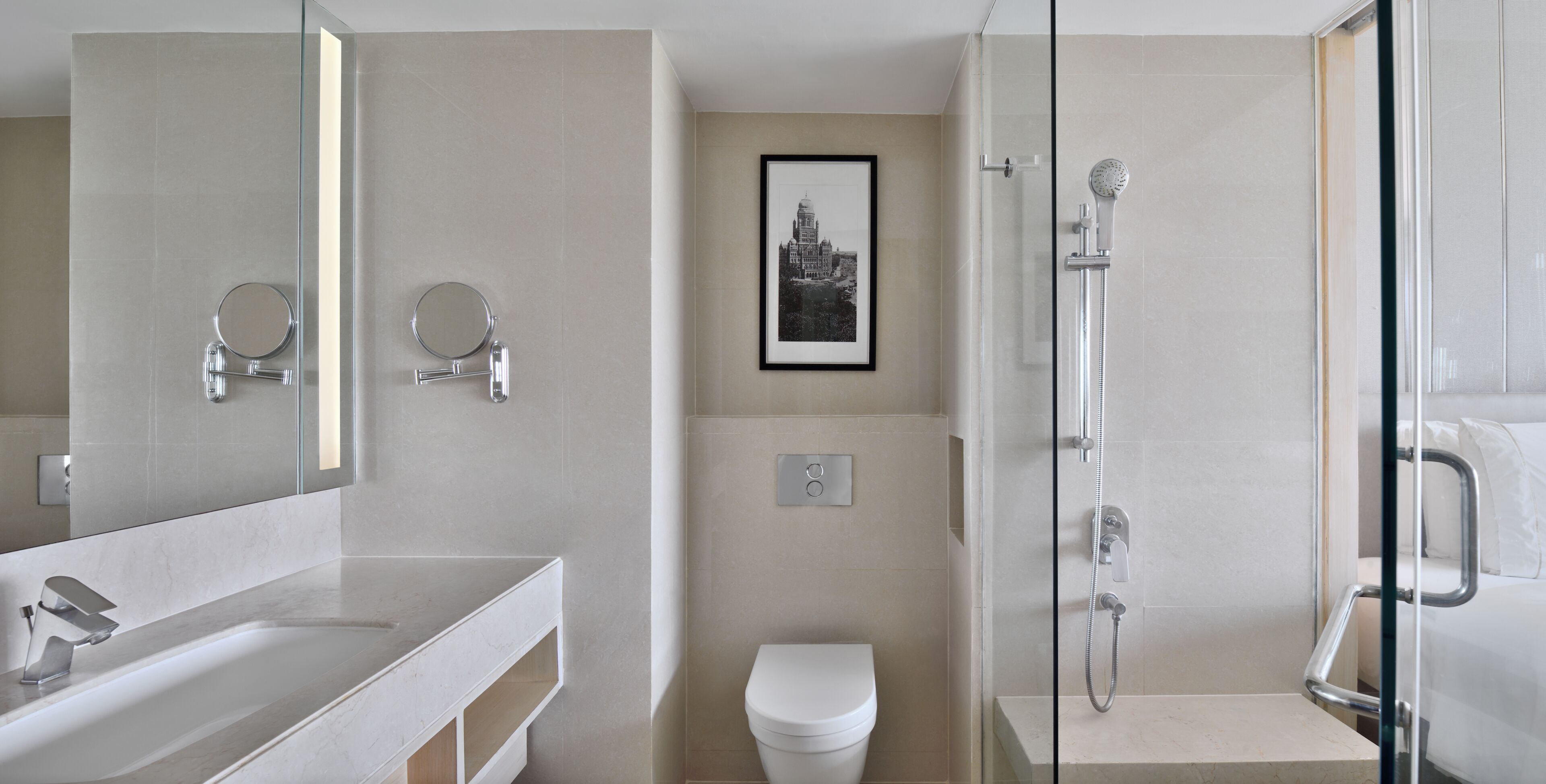 Een moderne badkamer met een douchecabine van glas, een toilet en een wastafel met spiegel.