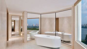 A modern bathroom with a large bathtub, a smaller tub, and a mirror.