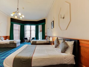 A hotel room with a large bed, two smaller beds, a desk, and a chair. - Lost Guest House Stirling (Stirling)