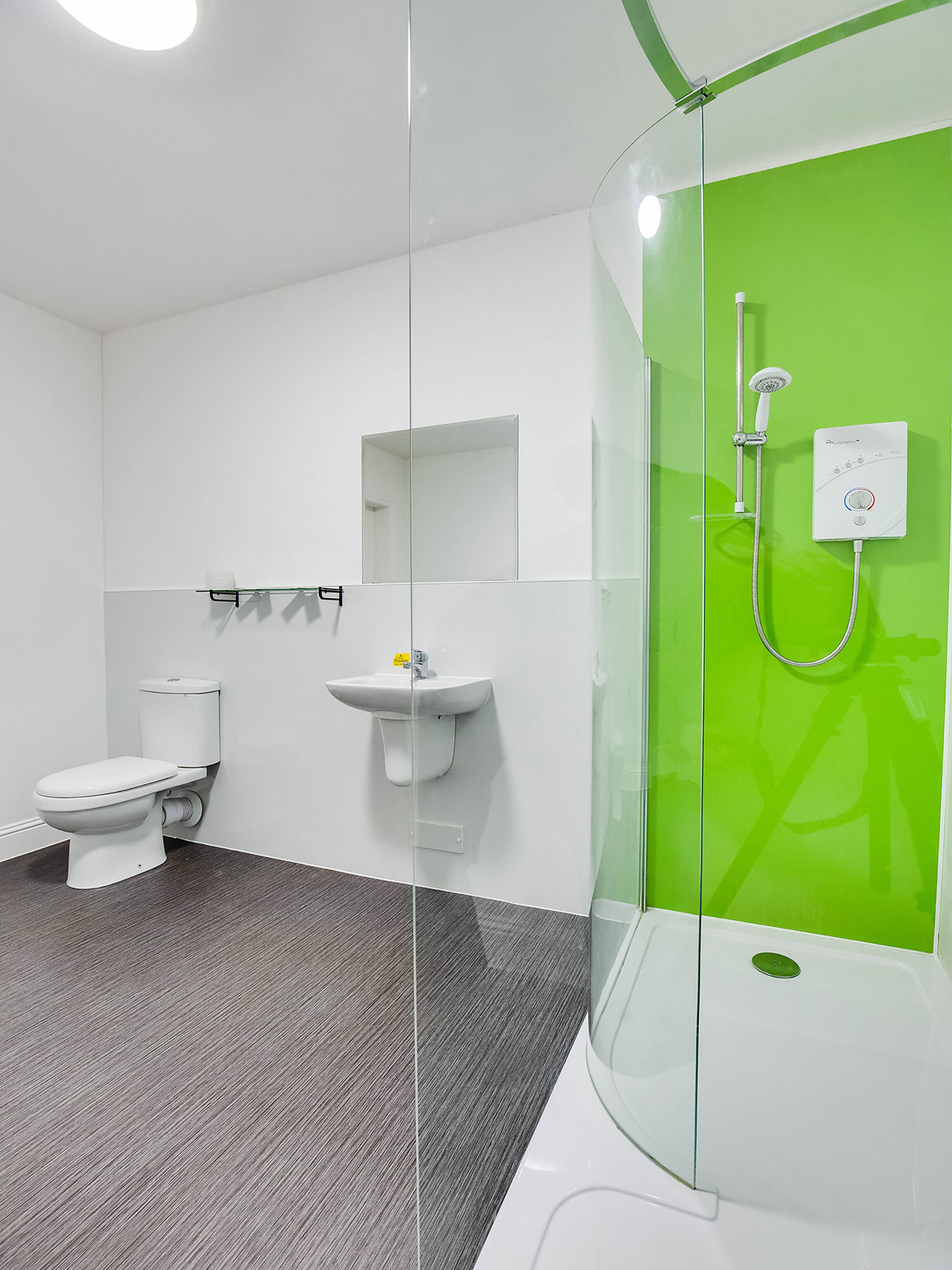 A modern bathroom with a toilet, sink, and shower.