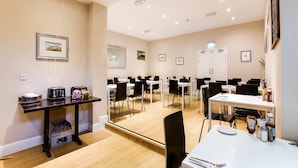 A conference room with multiple tables and chairs, a Breville toaster, and a Breville coffee maker on a counter. - Lost Guest House Stirling (Stirling)