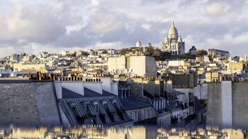 A cityscape with a prominent domed building, reflecting in a body of water.