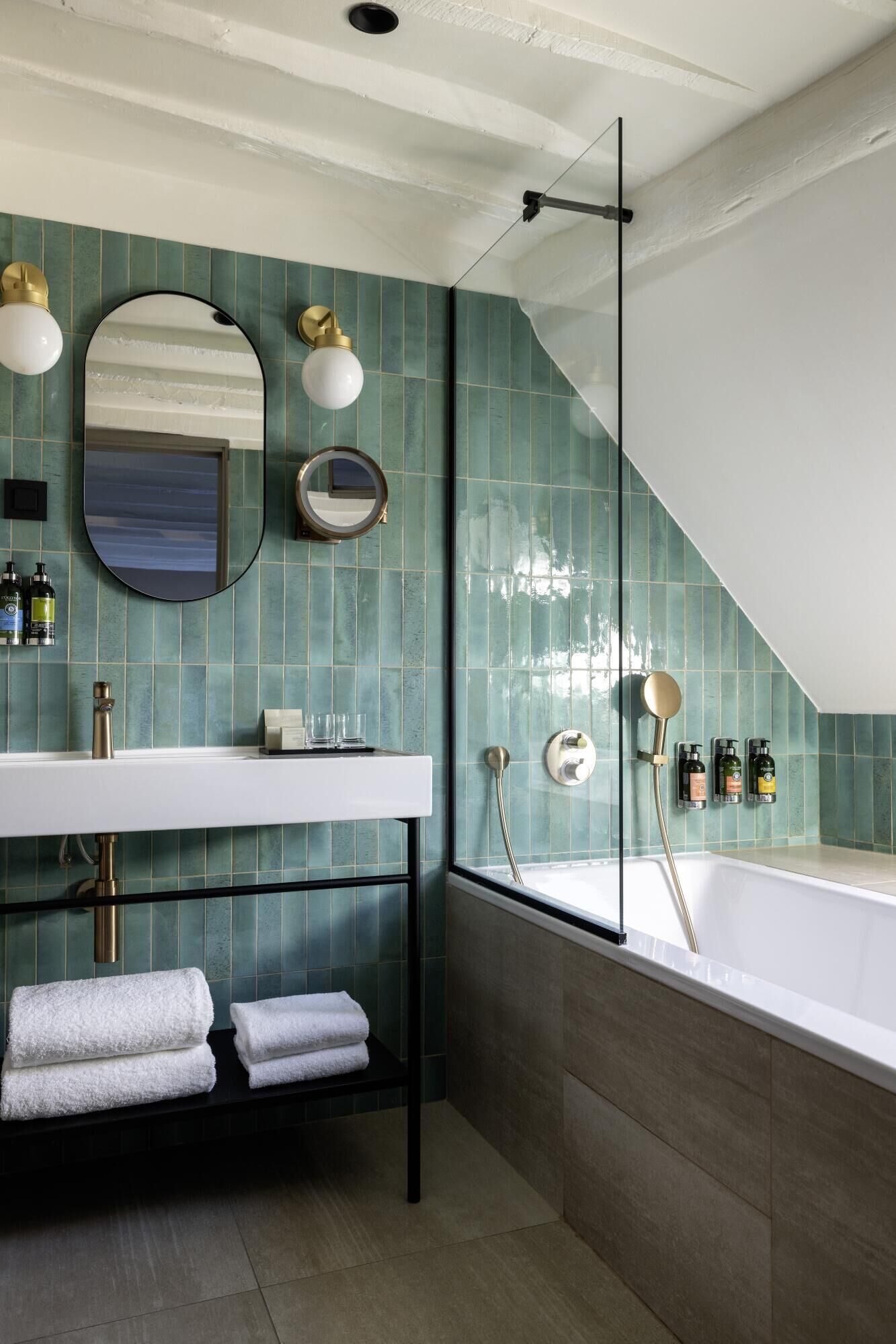Un baño moderno con una bañera independiente, un tocador con espejo y un perchero para toallas.