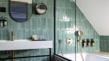 Un baño moderno con una bañera independiente, un tocador con espejo y un perchero para toallas.