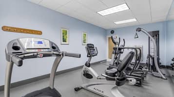 A gym with treadmills, elliptical machines, and weight equipment.