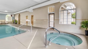An indoor swimming pool with clear water, metal railings, and a view of the outside through large windows. - Best Western Plus River Escape Inn & Suites (Dillsboro)