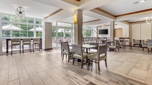 A spacious dining area with high ceilings, large windows, and modern furniture. - Best Western Plus River Escape Inn & Suites (Dillsboro)