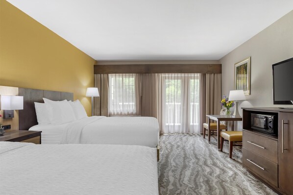 A hotel room with two beds, a desk with a chair, a television, and a microwave. - Best Western Plus River Escape Inn & Suites (Dillsboro)