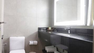 A modern bathroom with a toilet, sink, and shower.