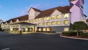 A hotel with a modern design, featuring a central entrance, multiple windows, and a well-lit facade.