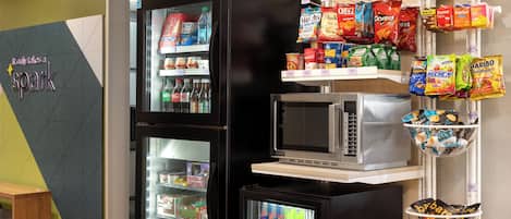 A vending machine area with snacks and beverages, a microwave, and a refrigerator.