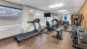 A fitness center with treadmills, elliptical machines, and weight equipment.
