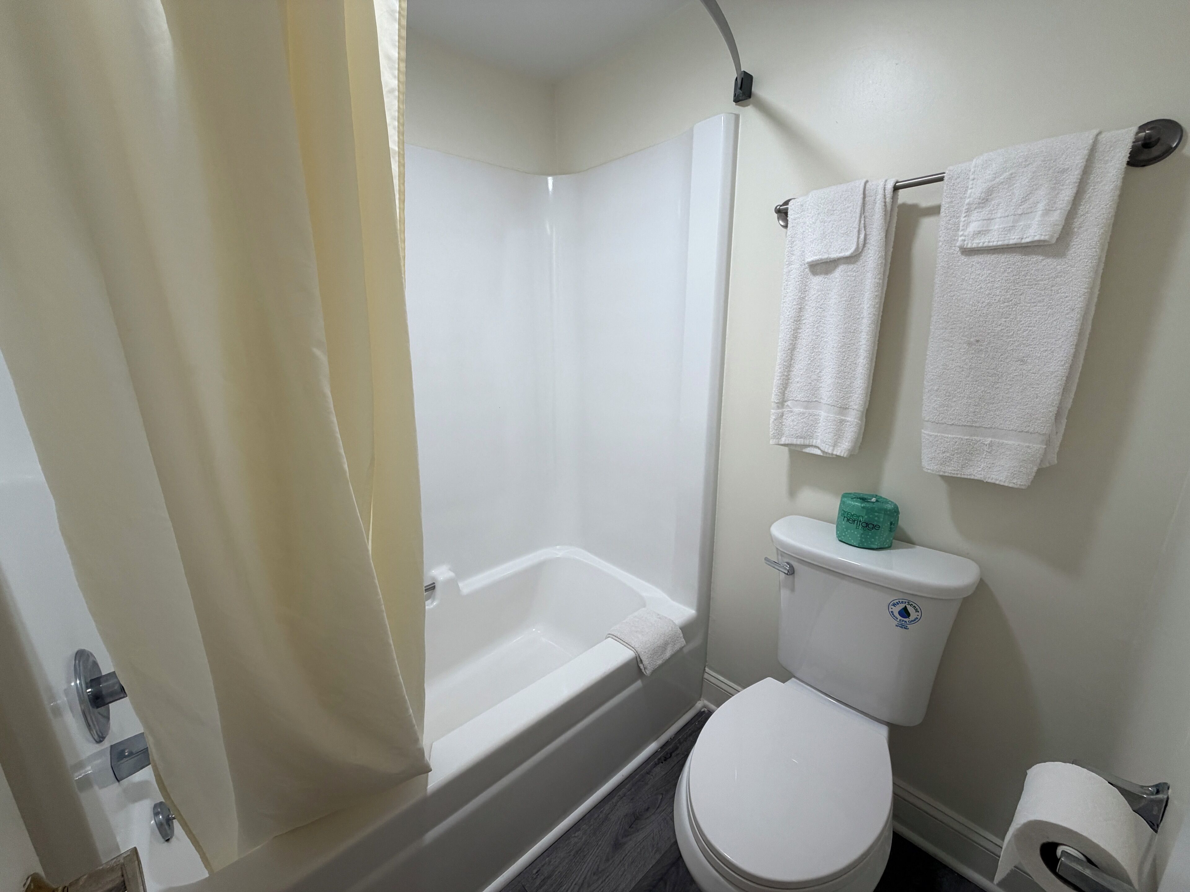 Une salle de bain équipée d’une baignoire, de toilettes et d’un sèche-mains.
