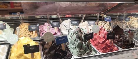 A variety of ice cream flavors in a display case, including mango, chocolate, and vanilla.